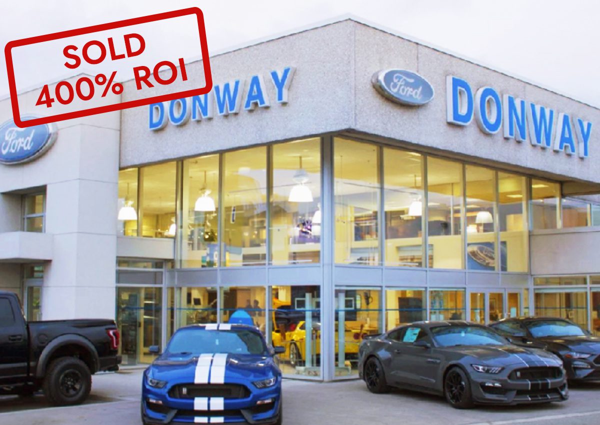 Car dealership with multiple vehicles and a 'SOLD' sign.