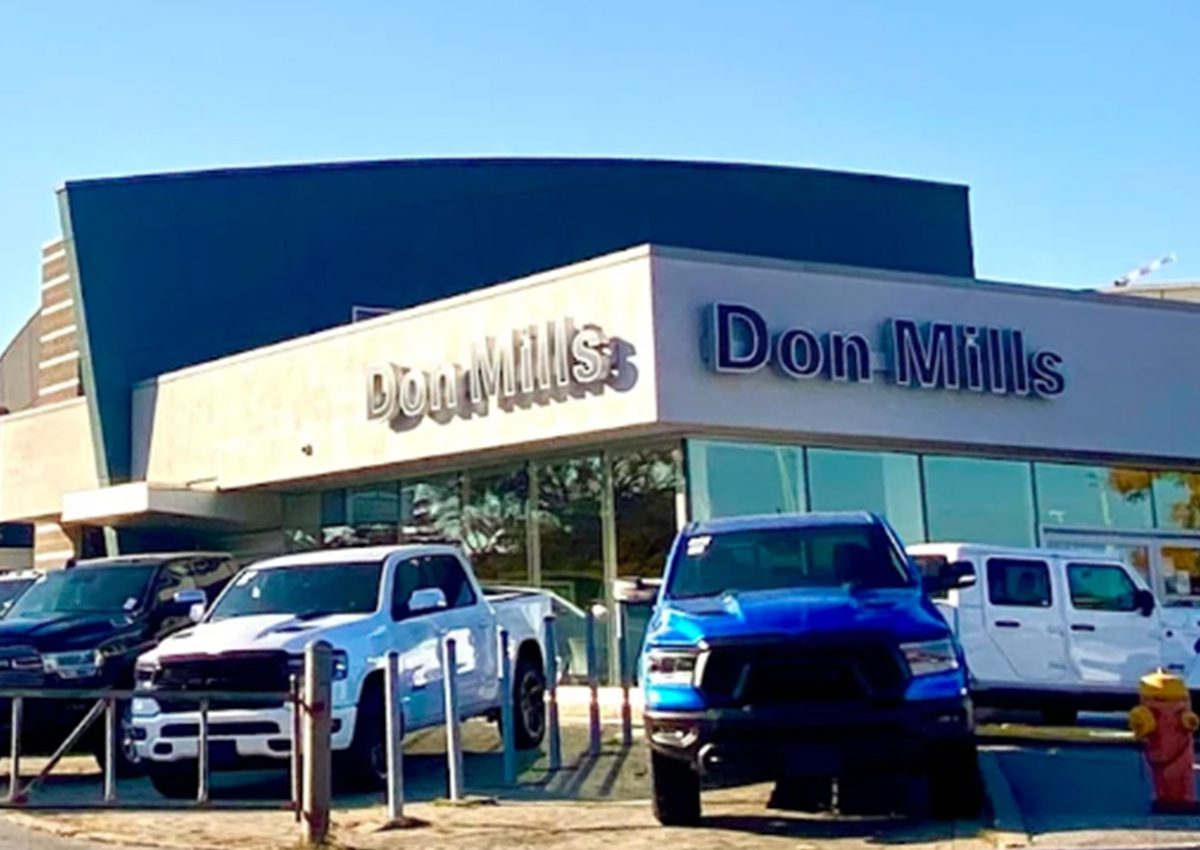 Exterior view of a Domino's Pizza with parked cars outside.
