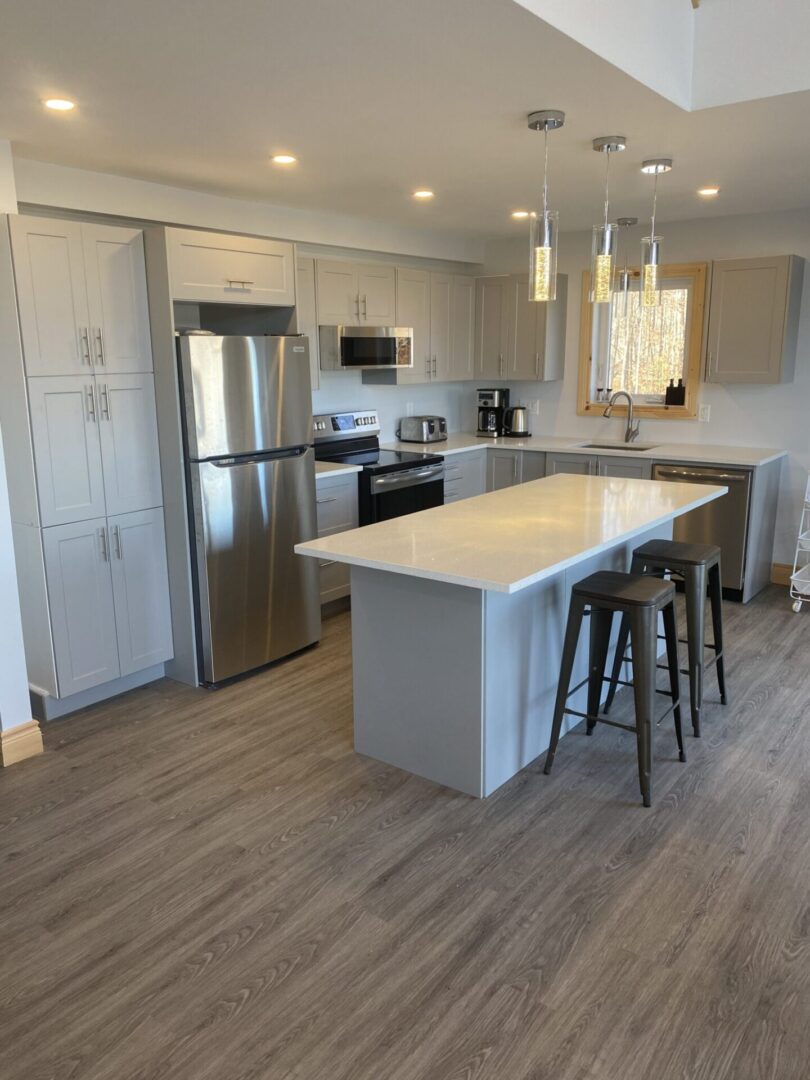 Modern kitchen with island and stainless steel appliances.