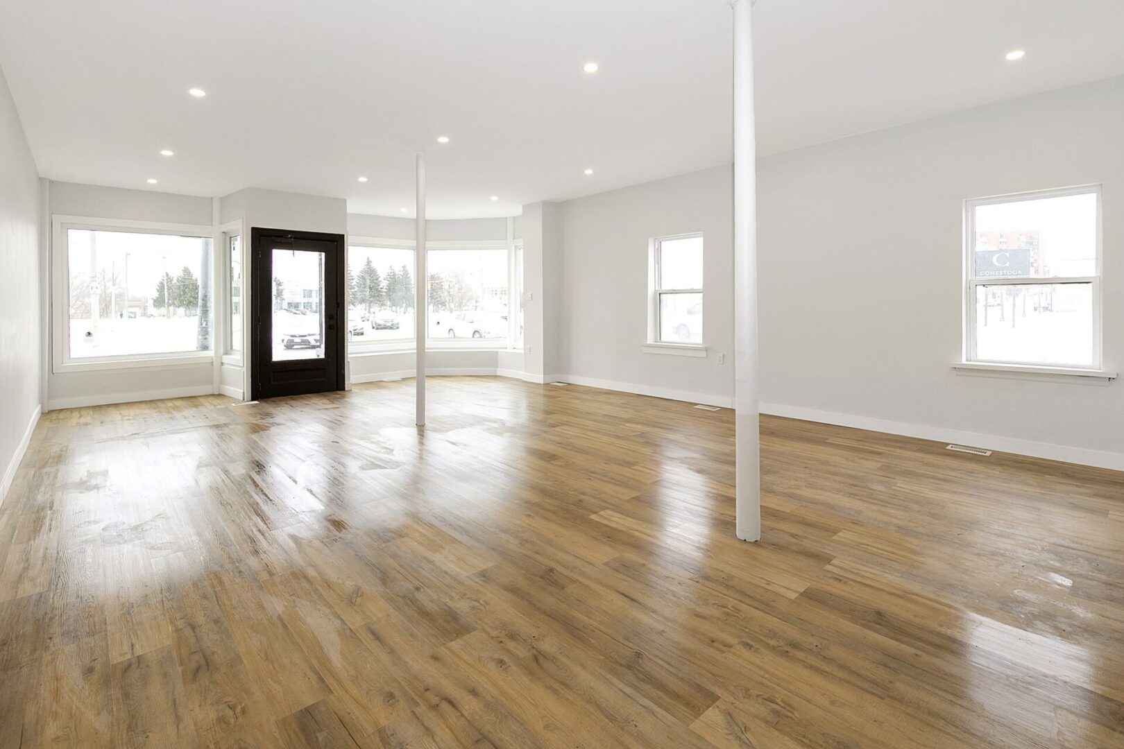 Bright, empty room with wooden floors and white walls.