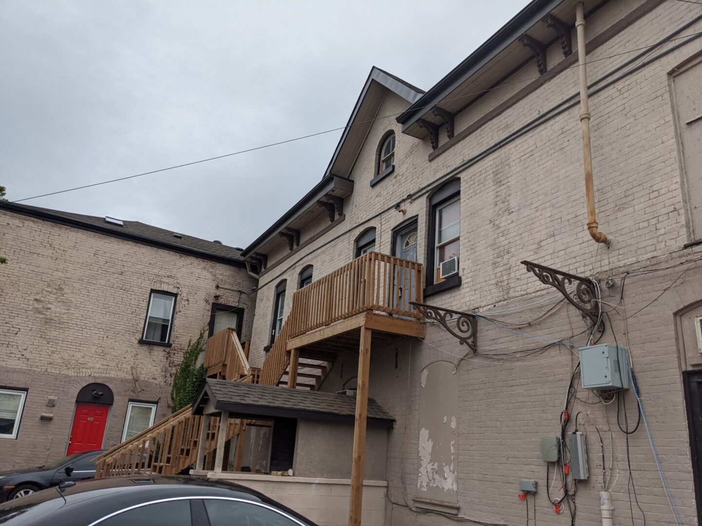 Old stone building with a wooden balcony under a cloudy sky.