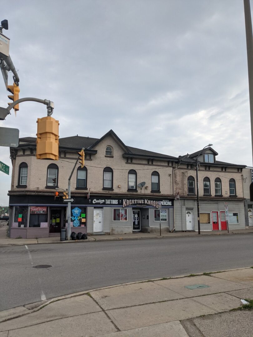 Historic stone building with shops under a cloudy sky.