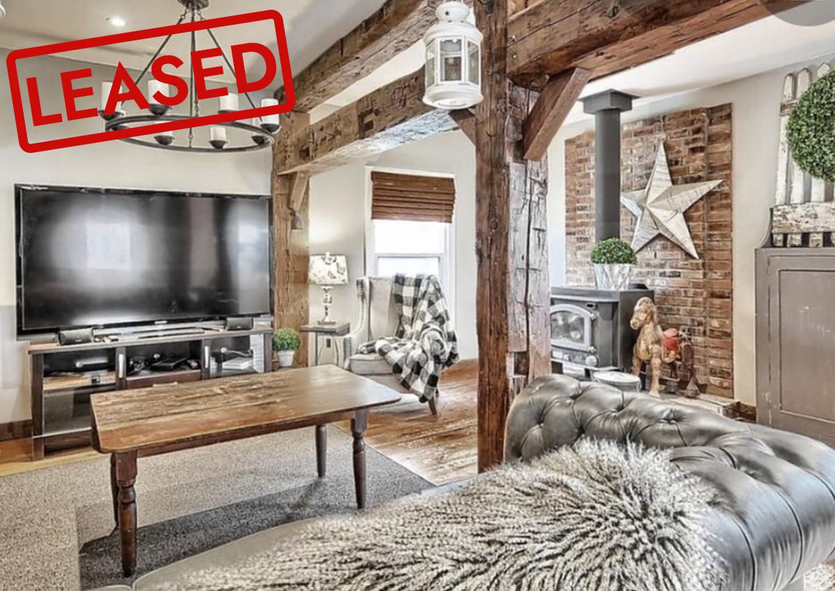 Cozy rustic living room with exposed wood beams and a fireplace.