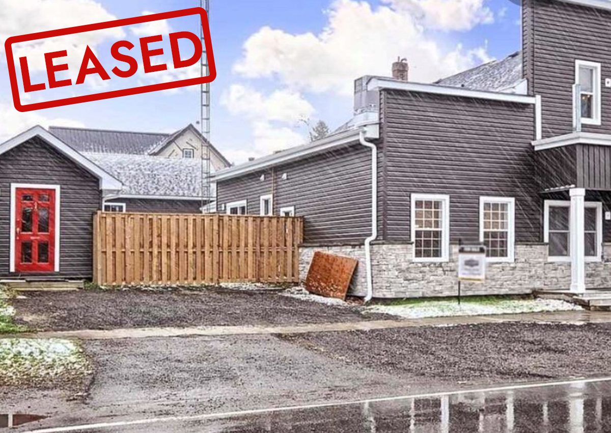 Newly fenced residential area with grey houses and a sold sign.