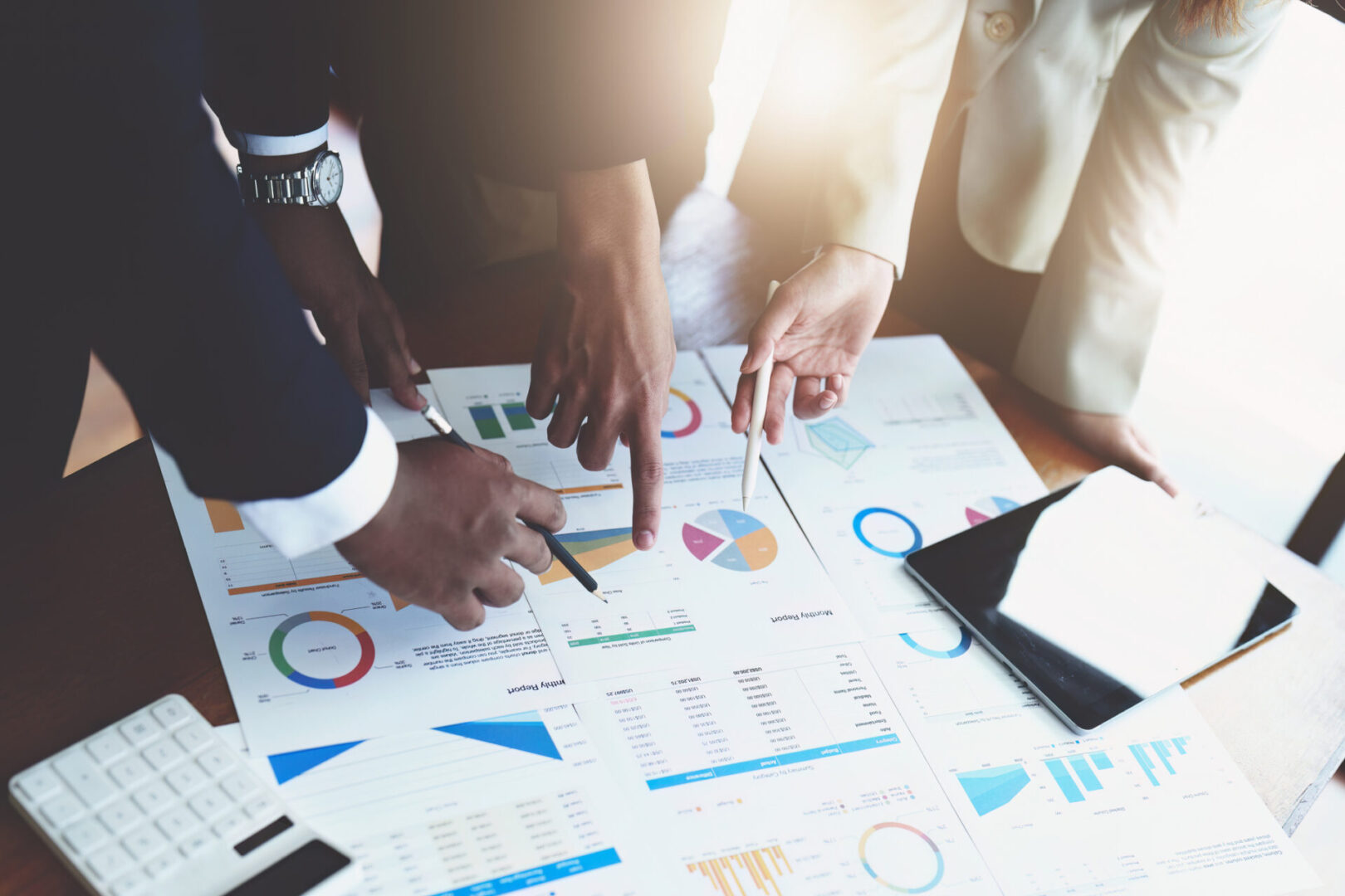 Team analyzing financial charts and data on a table.