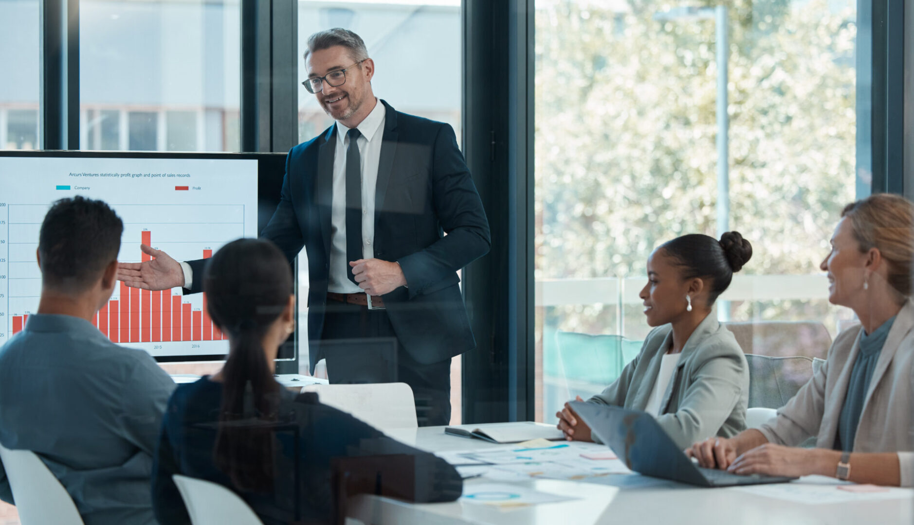 Businesswoman presents to colleagues in modern office meeting.