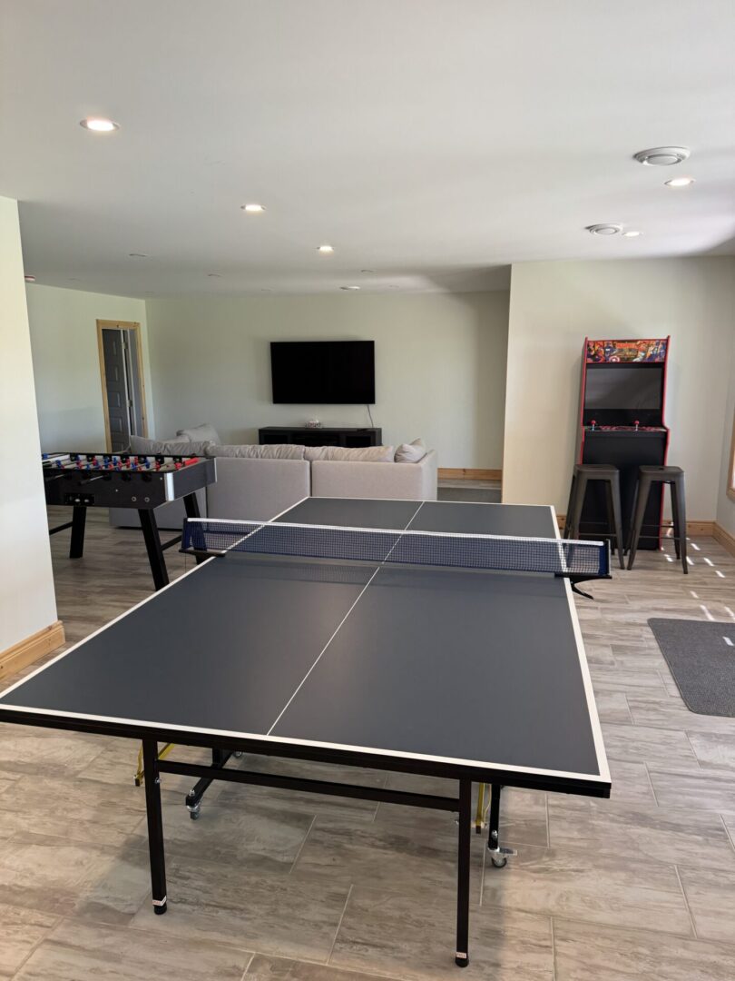 Indoor recreation room with ping pong and arcade games.