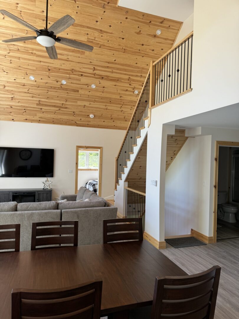 Modern living room with a wooden staircase and ceiling.