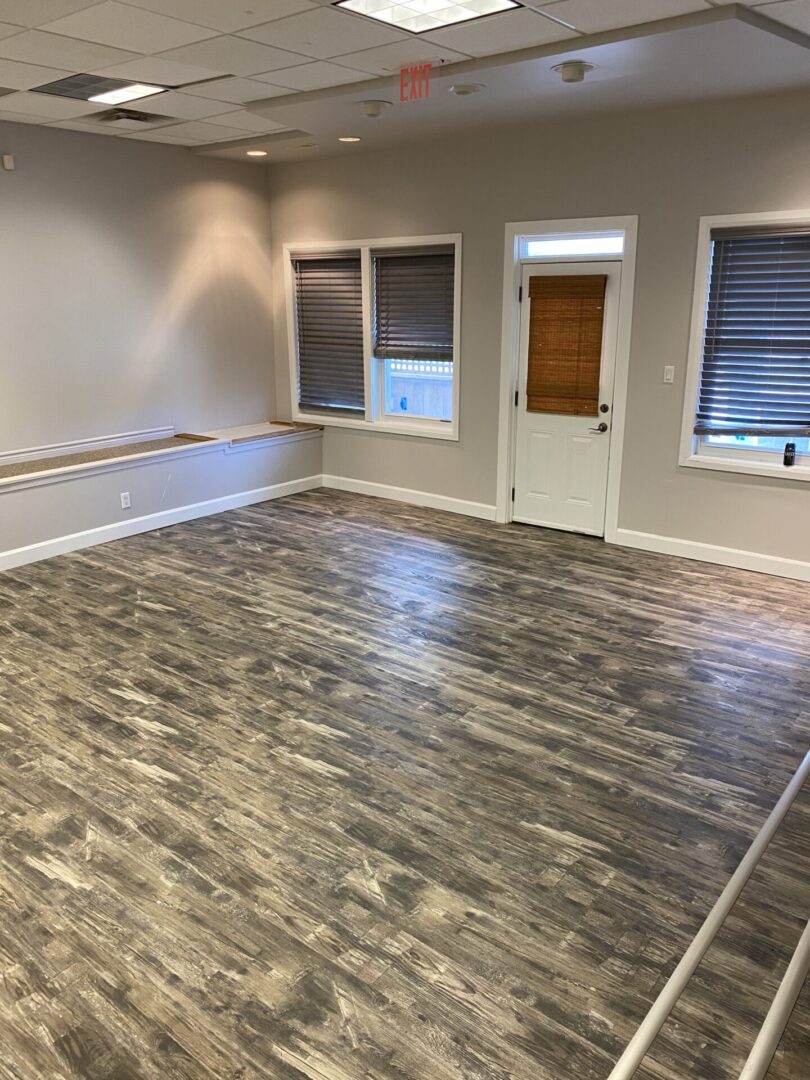 Empty room with wood-look flooring and built-in bench seating.