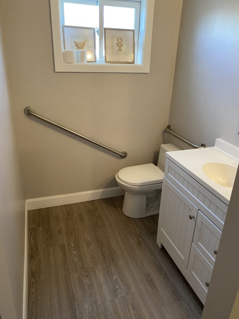 Small accessible bathroom with grab bars and a window.