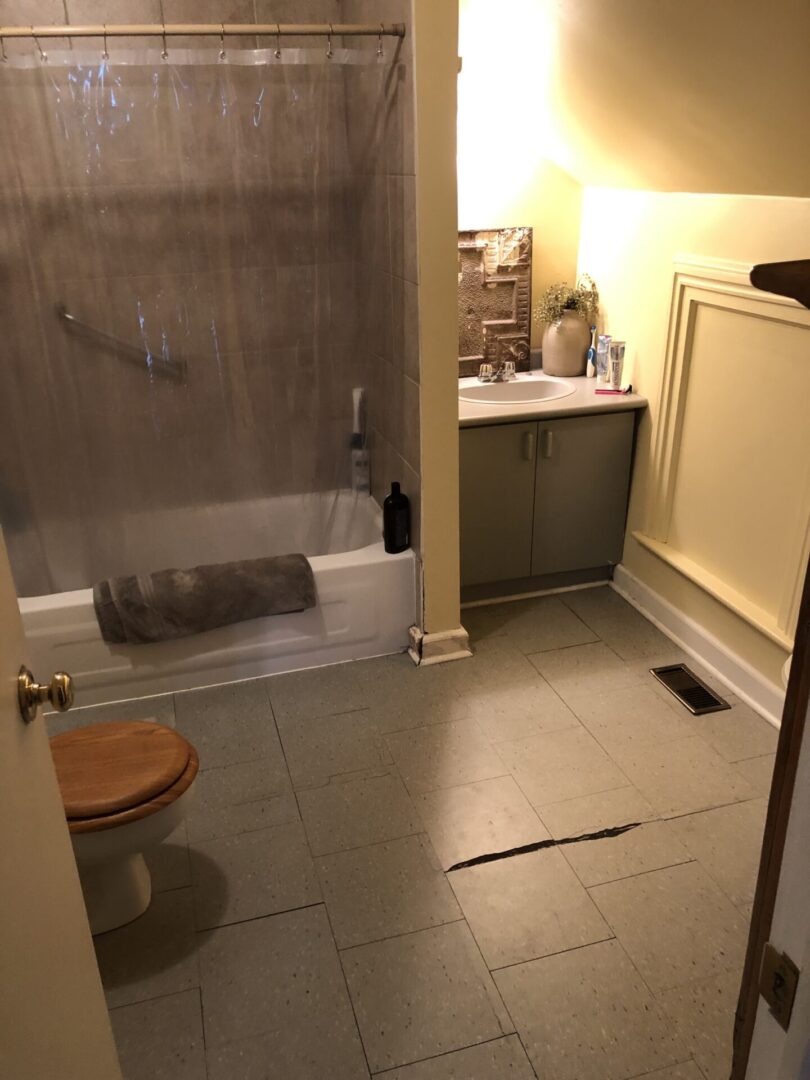 Cozy bathroom with wooden toilet seat and beige tiles.