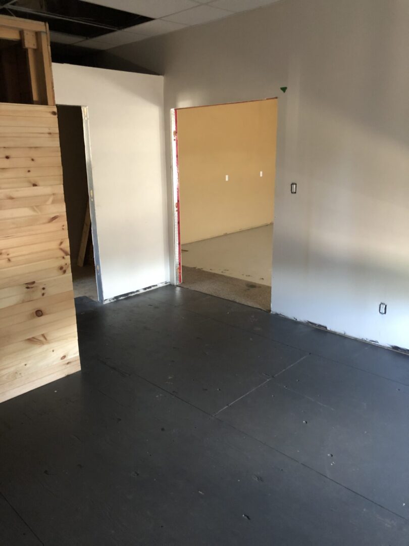 An unfinished room with tiled floor and bare walls.