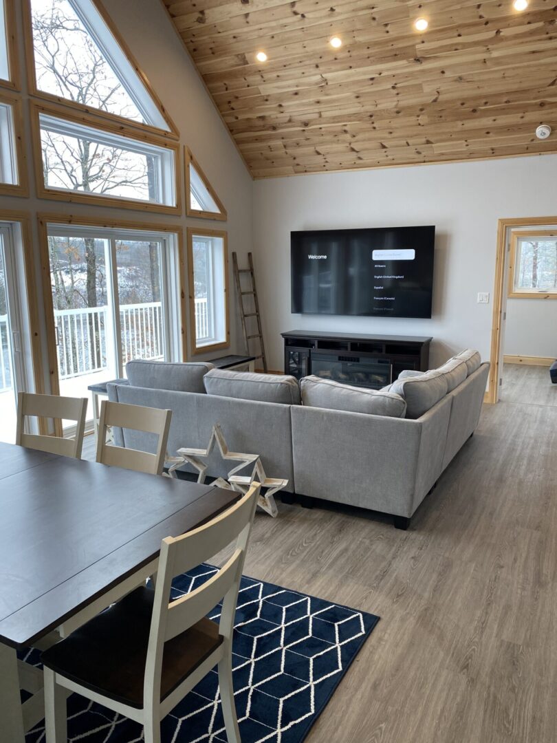 Cozy living room with large windows and a gray sectional sofa.