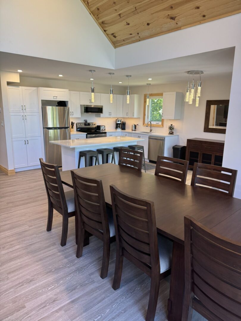 Modern kitchen and dining area with wooden furniture and neutral tones.